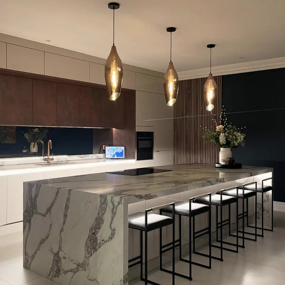 Kitchen with a marble-effect waterfall island and brass pendant lights